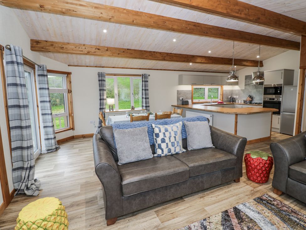 A living room with a sofa and dining area at Willow Lodge in Admaston near Abbots Bromley