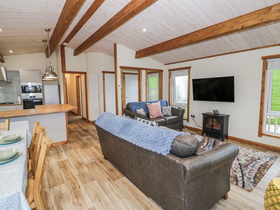 A living room with sofa and dining area at Willow Lodge in Admaston near Abbots Bromley
