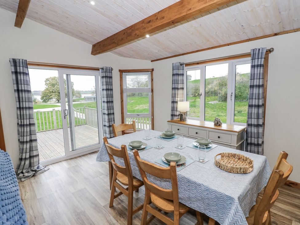 A dining room with a table set for meals at Willow Lodge in Admaston near Abbots Bromley