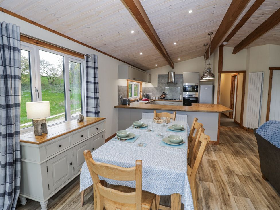 A dining room with a table and chairs at Willow Lodge in Admaston near Abbots Bromley