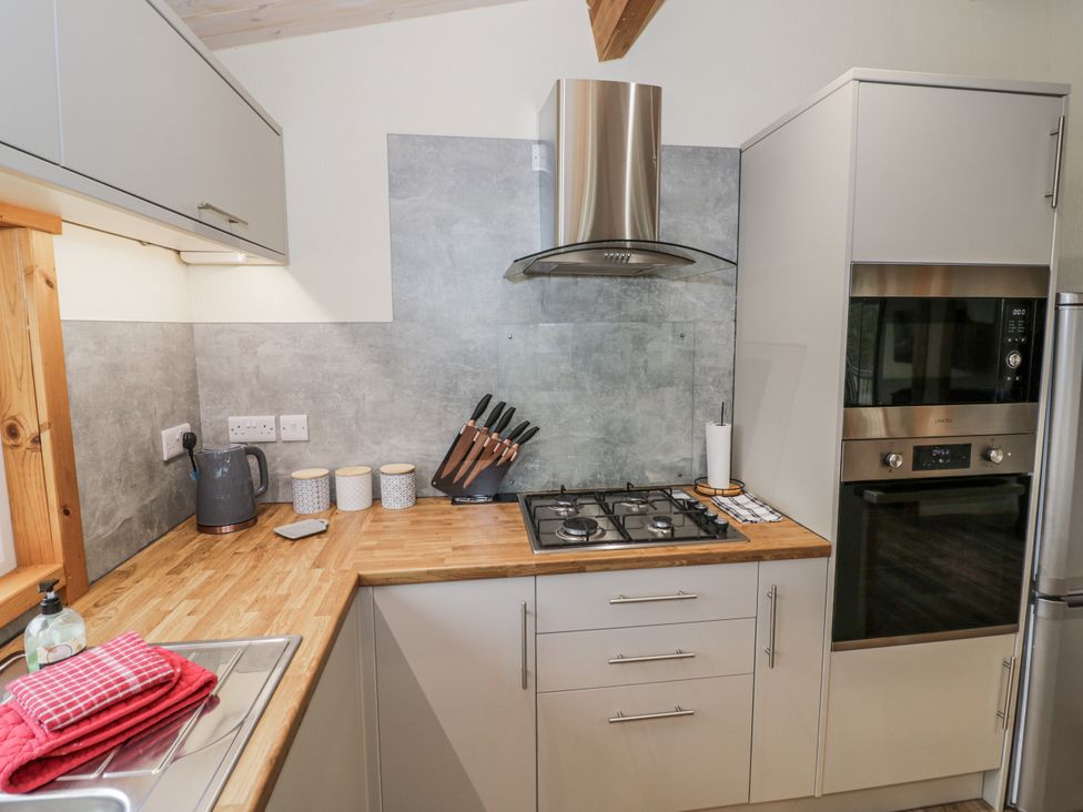 A kitchen with cabinets, a gas stove and utensils at Willow Lodge Admaston near Abbots Bromley
