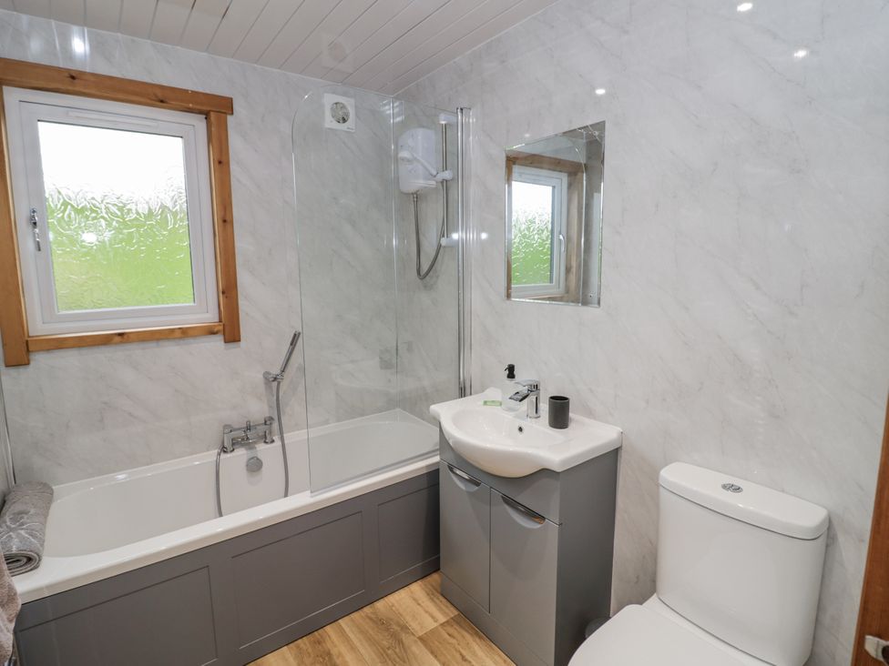 A bathroom with a bathtub, sink, and toilet at Willow Lodge in Admaston near Abbots Bromley