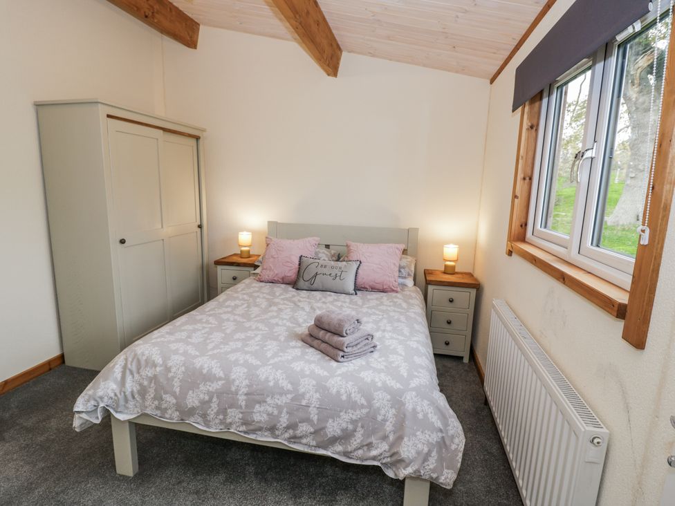A bedroom with a bed and wardrobe at Willow Lodge in Admaston near Abbots Bromley