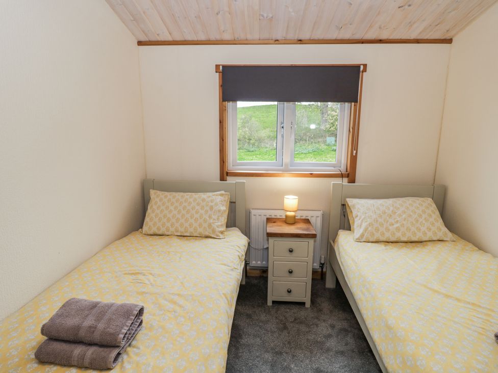 A bedroom with two single beds and a bedside table at Willow Lodge in Admaston near Abbots Bromley