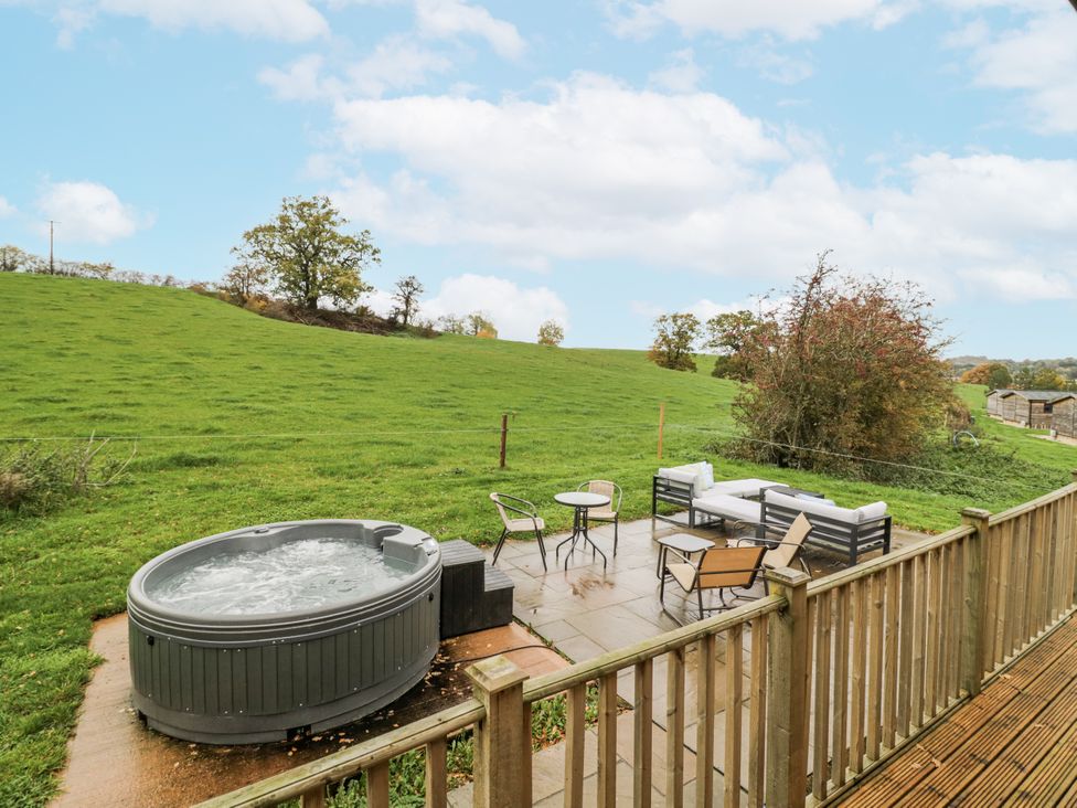 An outdoor area with a hot tub and seating at Willow Lodge in Admaston near Abbots Bromley