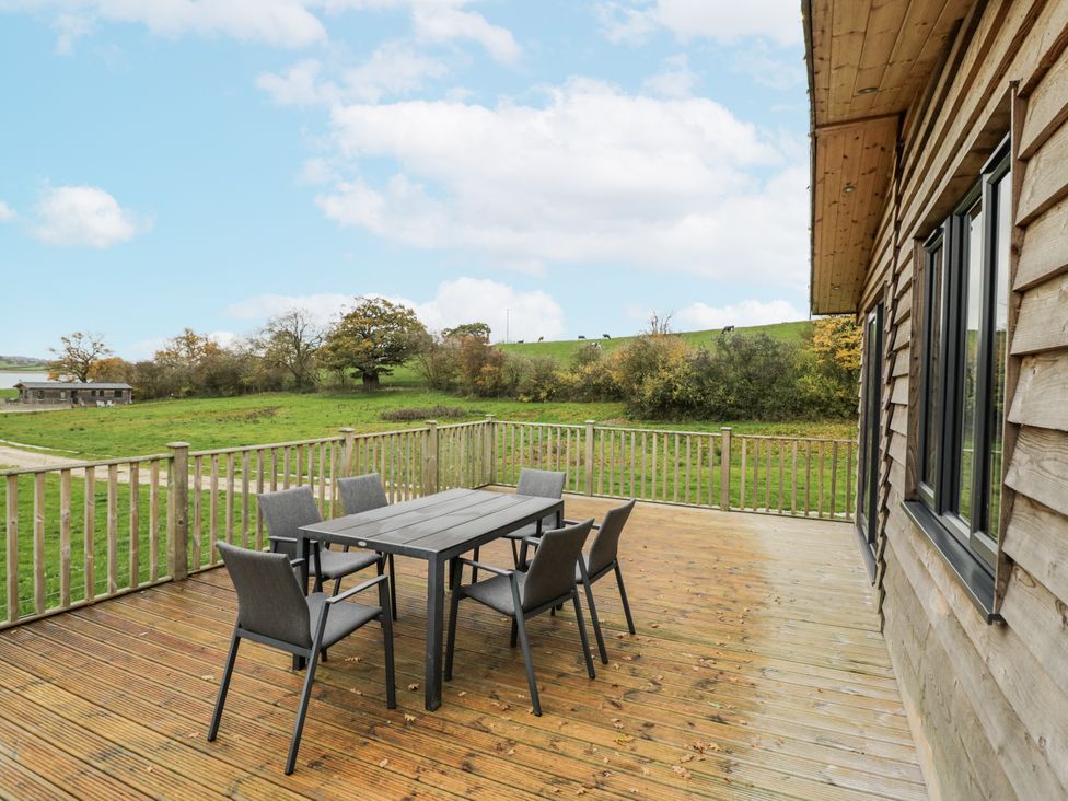 An outdoor seating area with a table and chairs at Willow Lodge in Admaston near Abbots Bromley