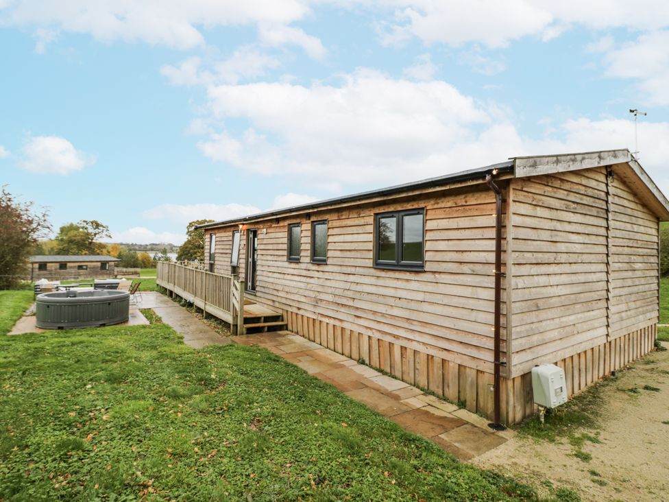 A wooden cabin with a hot tub and outdoor area at Willow Lodge in Admaston near Abbots Bromley