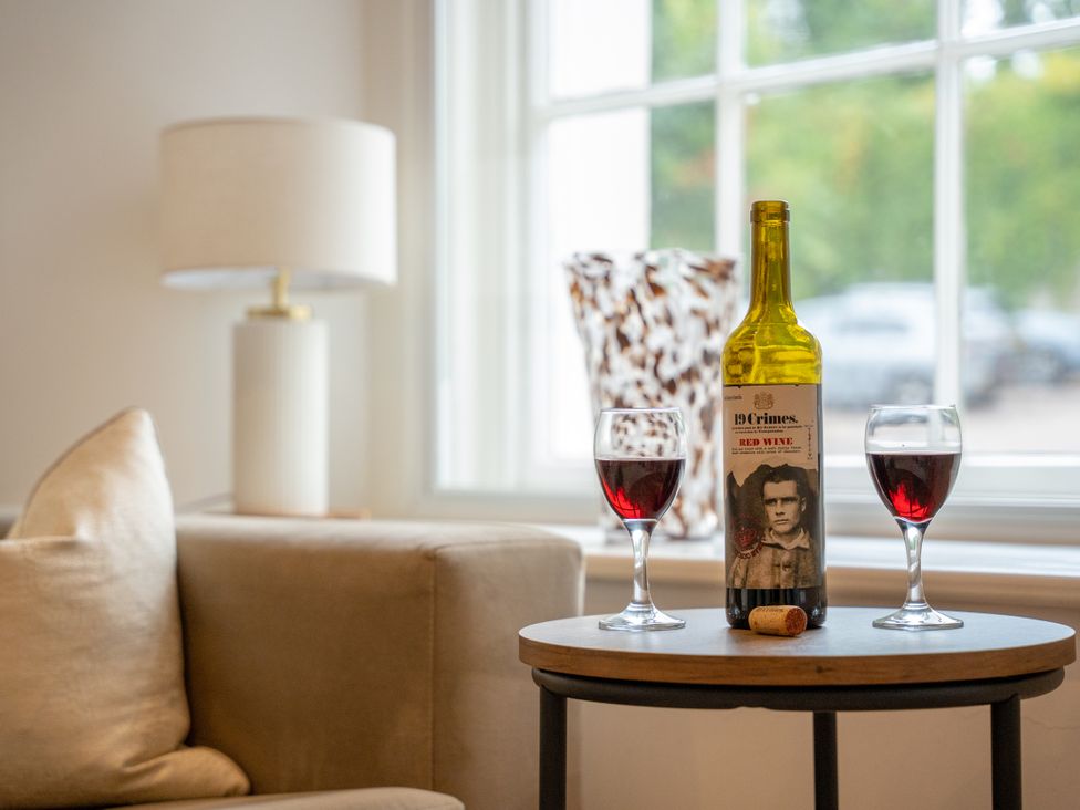 A table with wine and glasses in a living room at Derwent in Ulverston