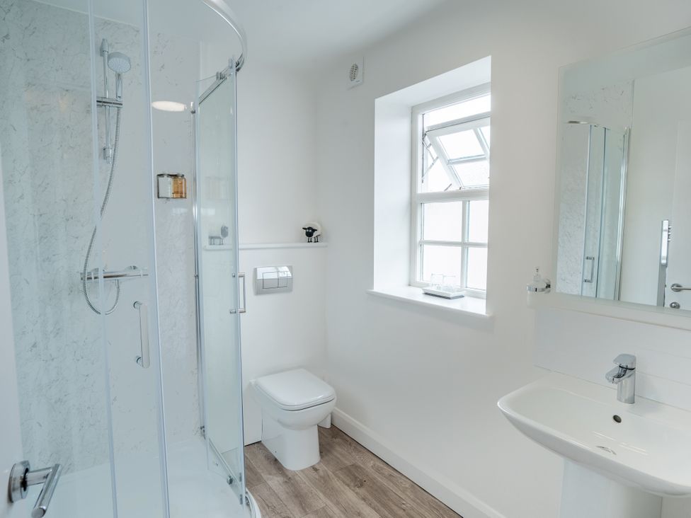 A bathroom with a shower, toilet, and sink at Derwent in Ulverston