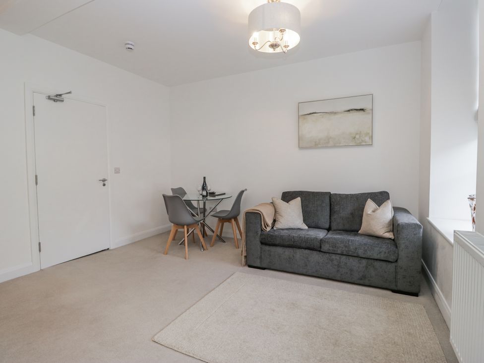 A living room with a sofa and dining table at Derwent in Ulverston