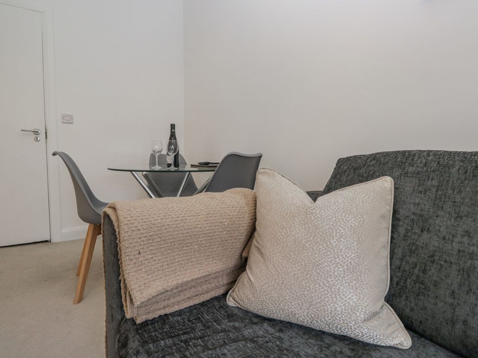 A living room with a sofa and dining area at Derwent in Ulverston