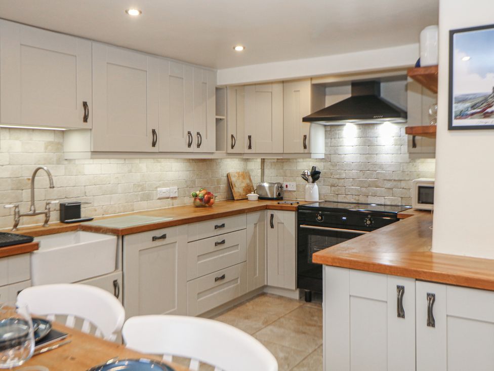 A kitchen with cabinets and appliances at Dorset Villas in Matlock