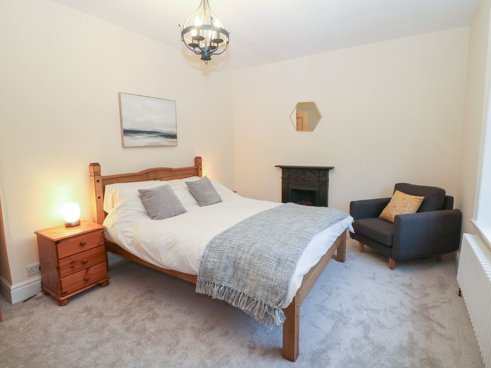 A bedroom with a bed and a chair at Dorset Villas in Matlock