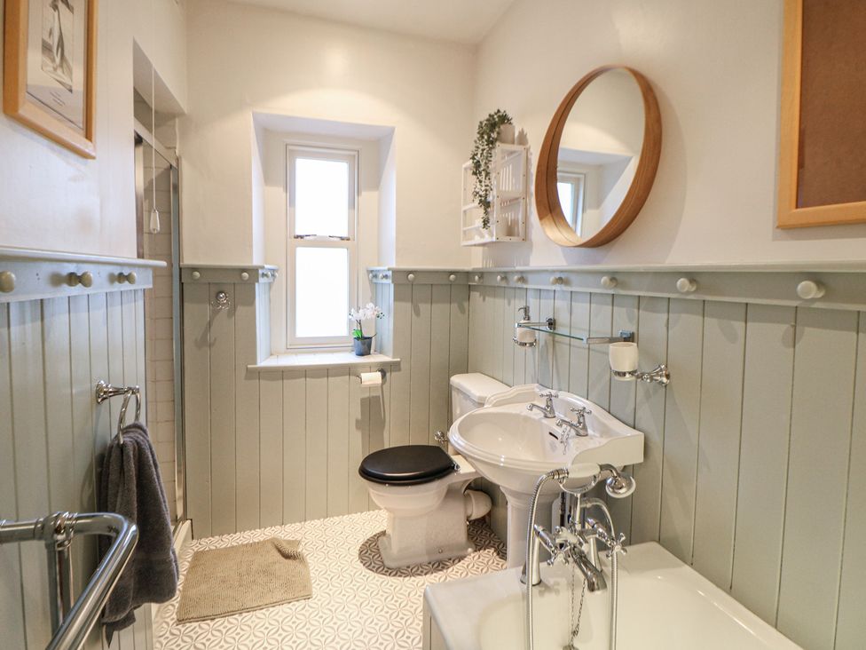 A bathroom with a toilet, sink, and bathtub at Dorset Villas in Matlock