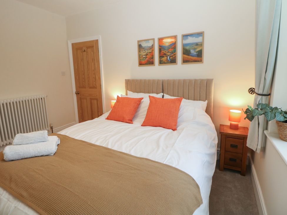 A bedroom with a bed and bedside table at Dorset Villas in Matlock
