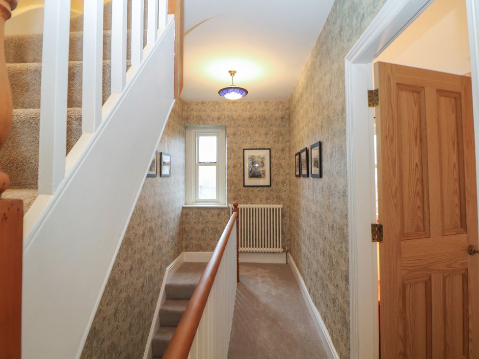 A hallway with stairs and a radiator at Dorset Villas in Matlock