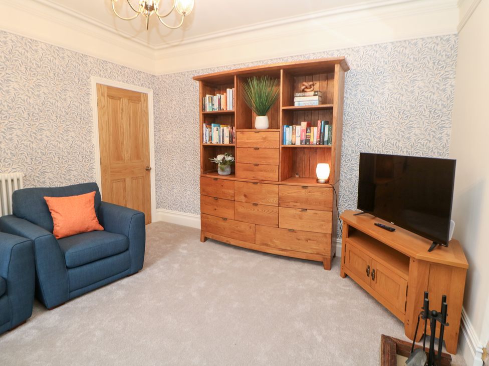 A living room with a sofa and bookshelf at Dorset Villas in Matlock
