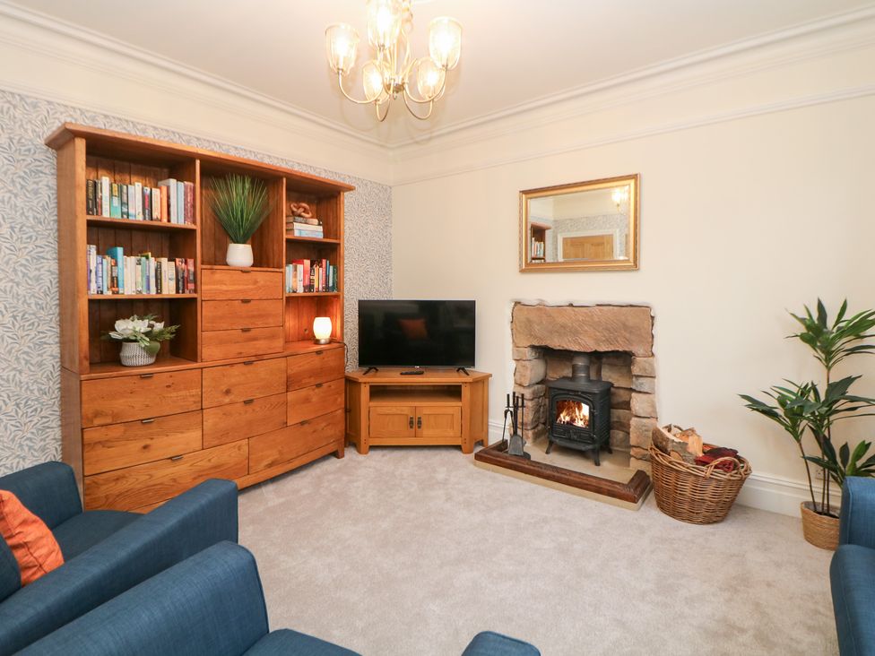 A living room with a television and fireplace at Dorset Villas in Matlock