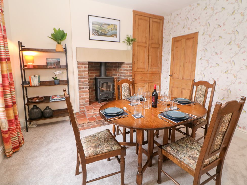 A dining room with a wooden table and chairs at Dorset Villas in Matlock