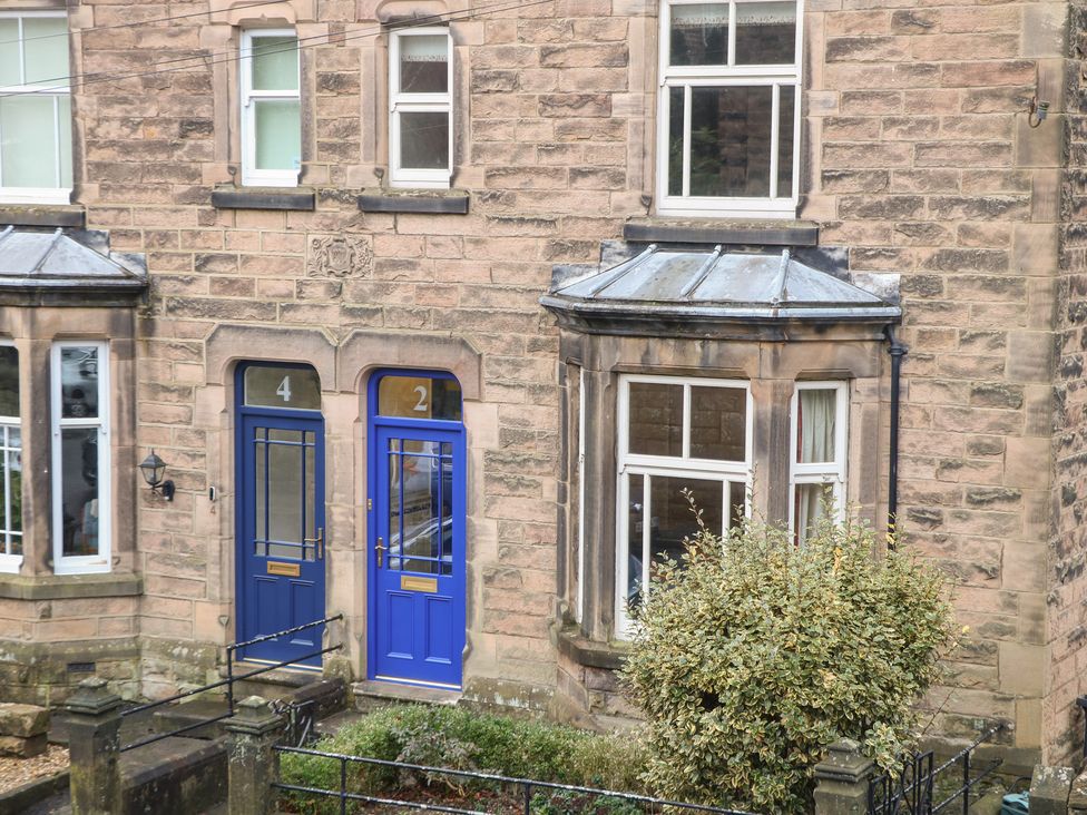 Two blue doors and windows on a stone building at Dorset Villas in Matlock