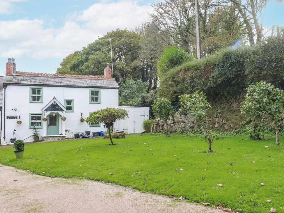 A cottage with a garden and trees at Blowing House Cottage in Perranporth