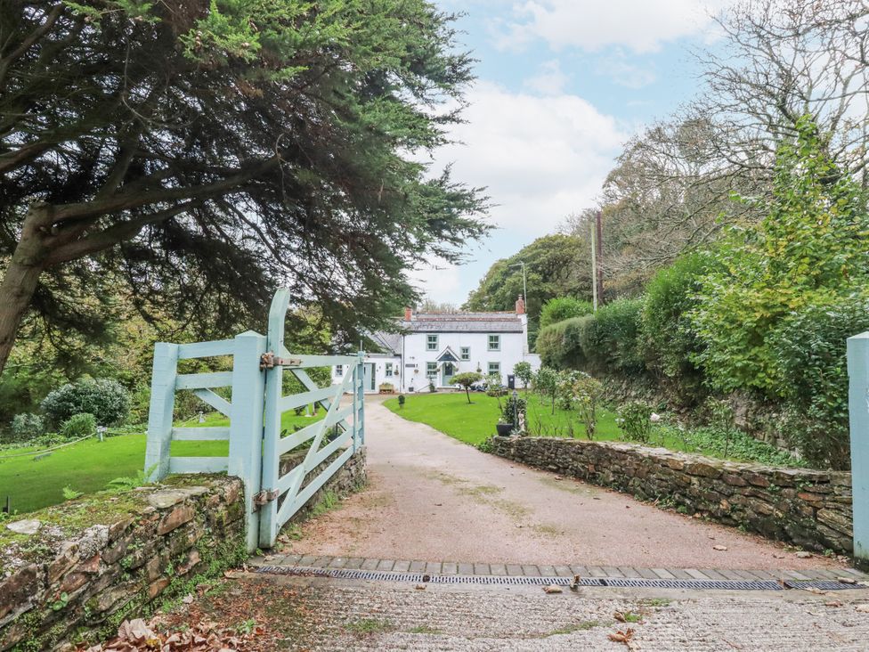 A house with a driveway and gate at Blowing House Cottage in Perranporth
