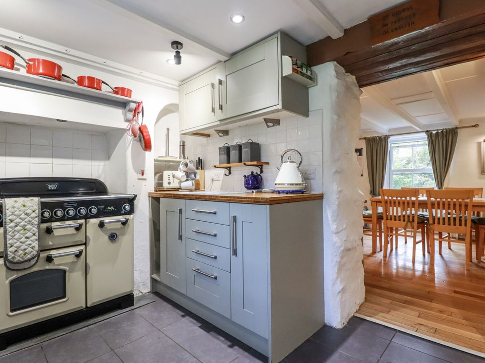 A kitchen with a stove and cabinets at Blowing House Cottage in Perranporth