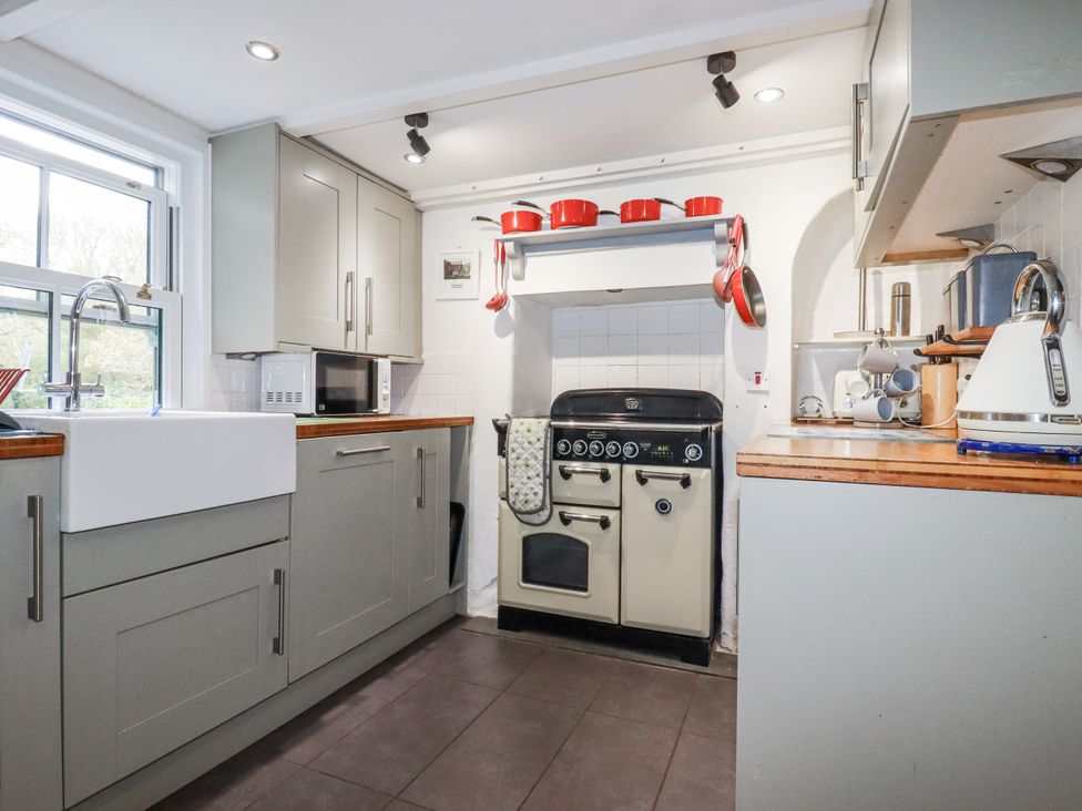 A kitchen with a sink and oven at Blowing House Cottage in Perranporth