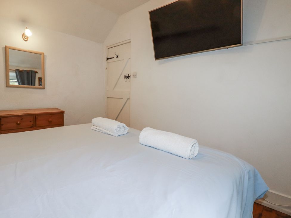 A bedroom with a bed and towels at Blowing House Cottage Perranporth