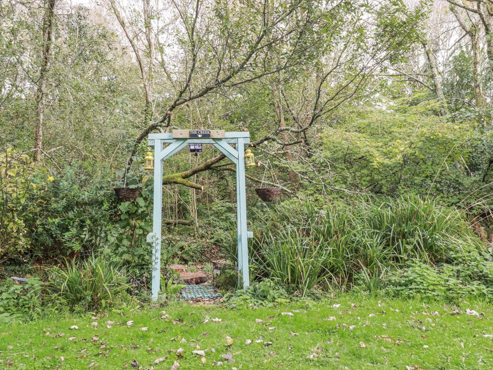 An archway leading to a pathway in a garden at Blowing House Cottage Perranporth
