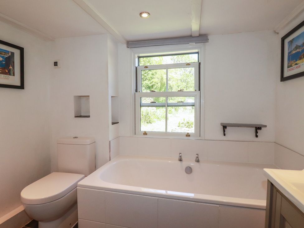 A bathroom with a toilet and bathtub at Blowing House Cottage near Perranporth