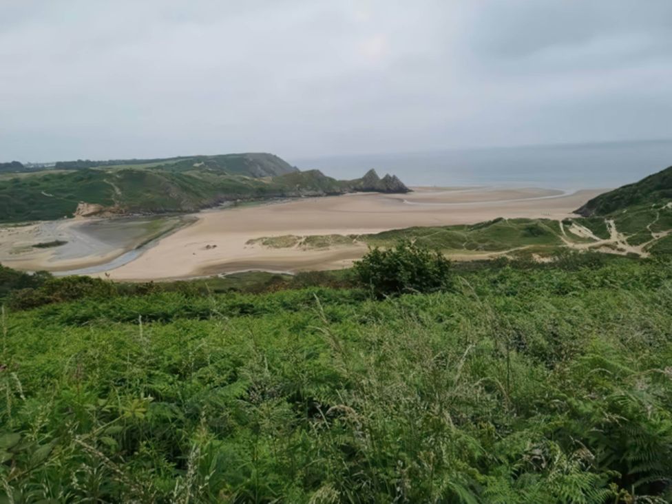 A view of the beach and ocean with cliffs in the background at 