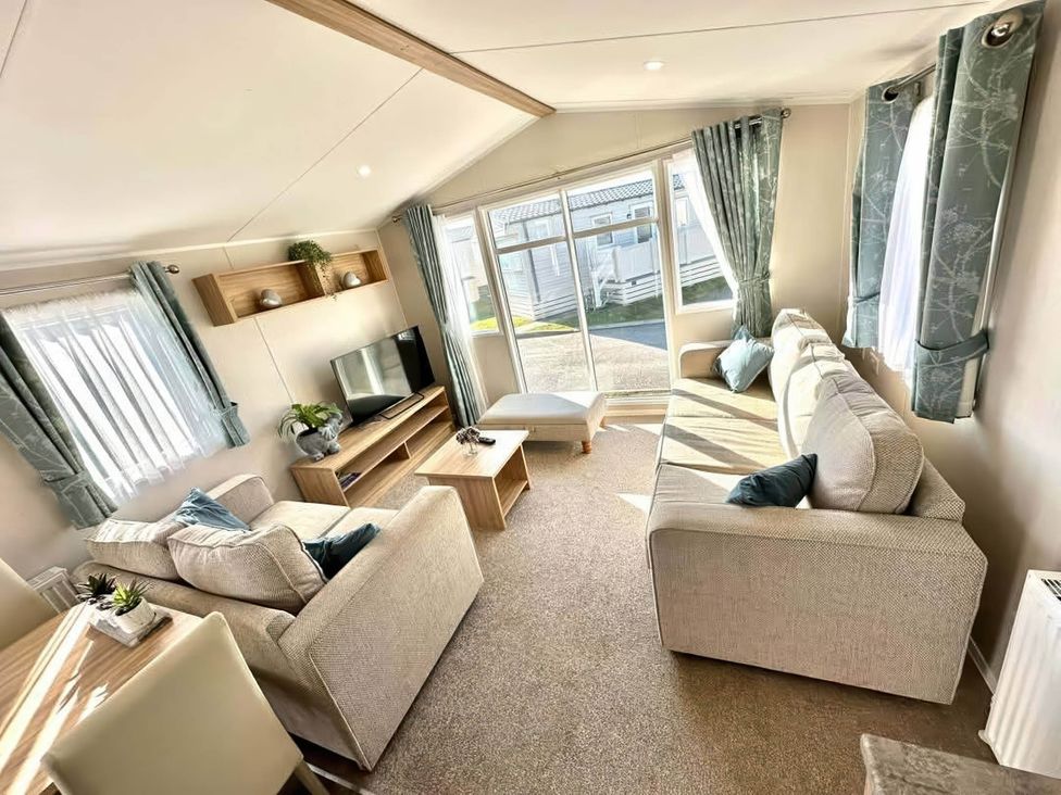 A living room with a television and sofas at the property in unknown location