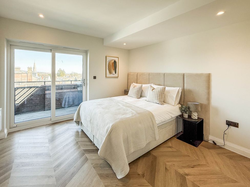 A bedroom with a bed and balcony door at The Old Barn in Manchester