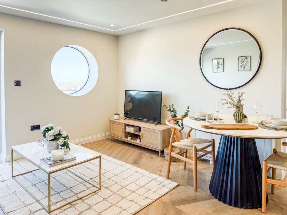 A living room with a television and dining table at The Old Barn in Manchester