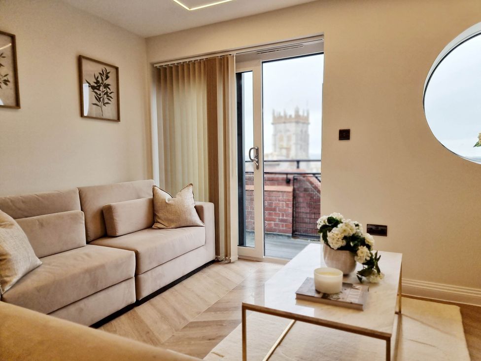 A living room with a sofa and table overlooking a balcony at the property in the location