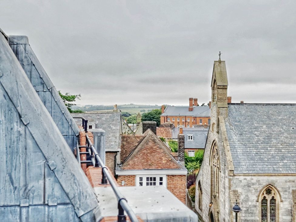 A view of rooftops and a church with hills in the background at the property in location