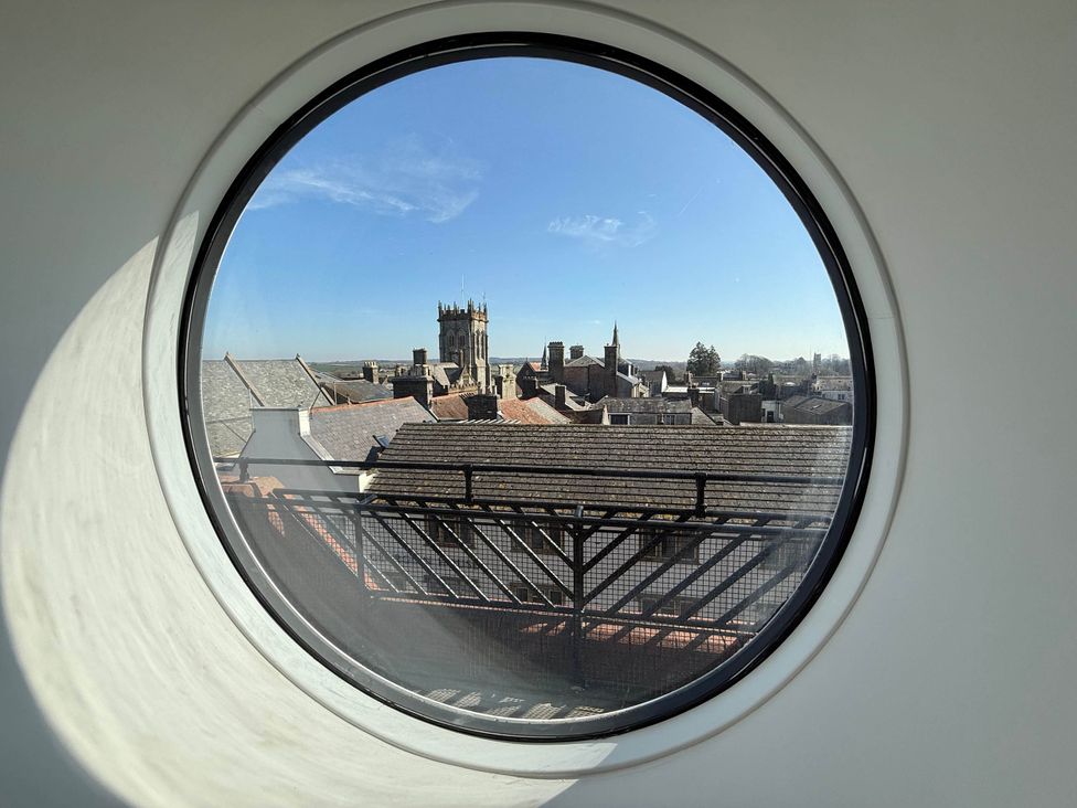 A view of rooftops and buildings through a round window