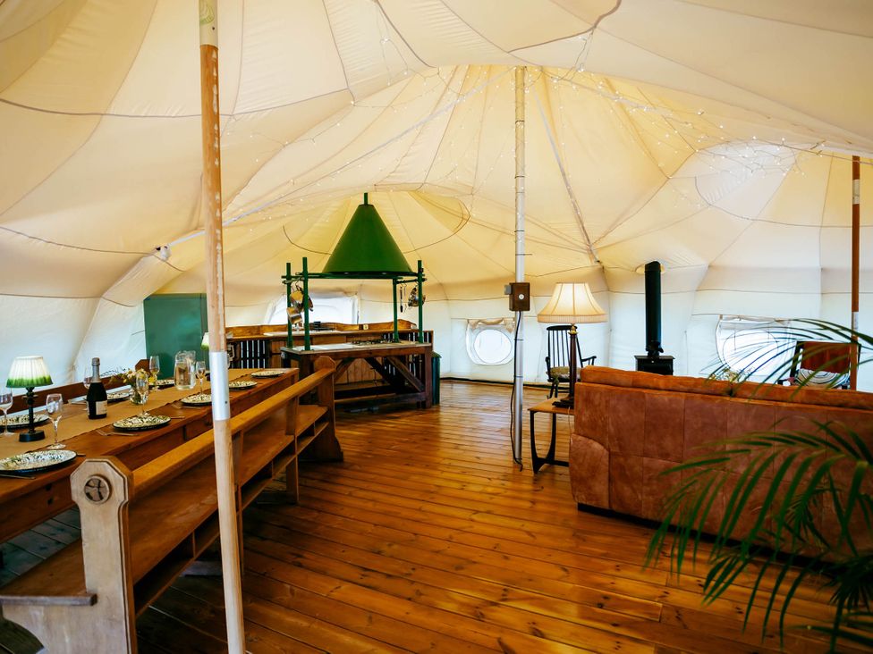 An indoor dining area with a table and chairs at a glamping tent