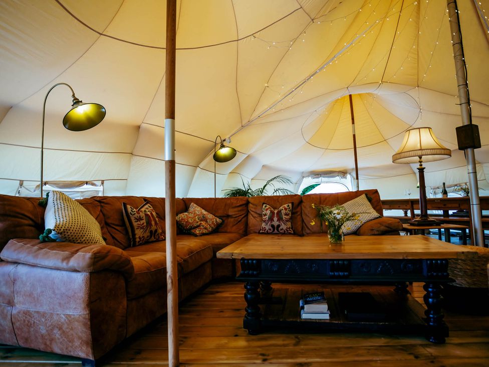 A living room with a sofa and coffee table in a tent