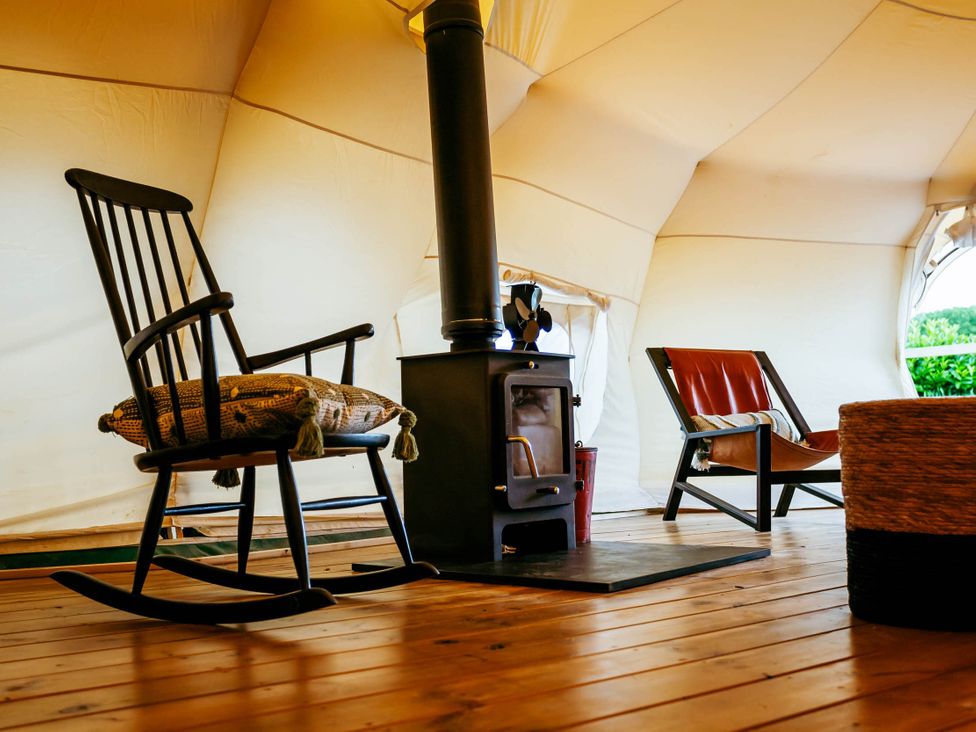 A seating area with chairs and a stove in a tent at 