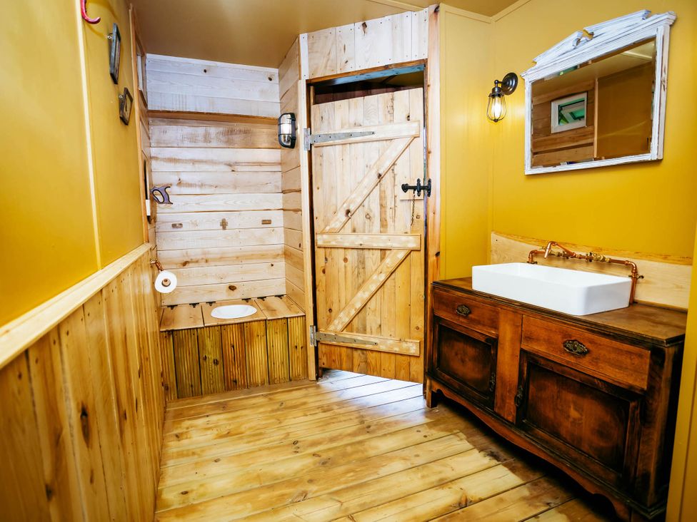 A bathroom with a wooden toilet and sink at The Old Barn in Manchester