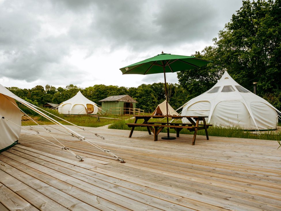 An outdoor area with yurts and a picnic table at a campsite