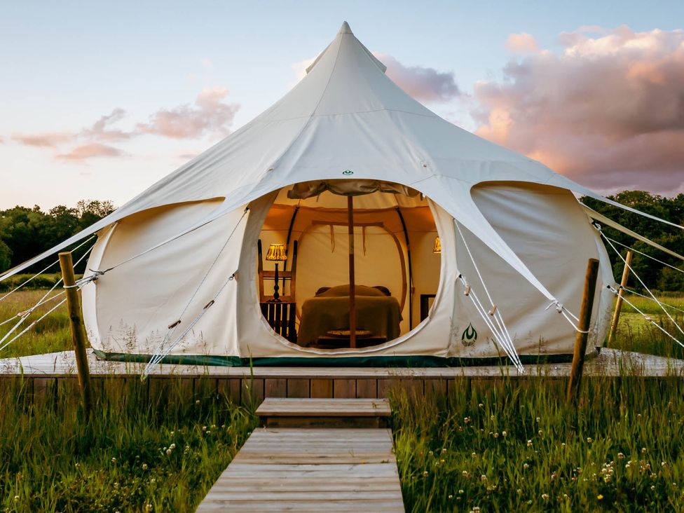 A tent with a bed inside at a glamping site