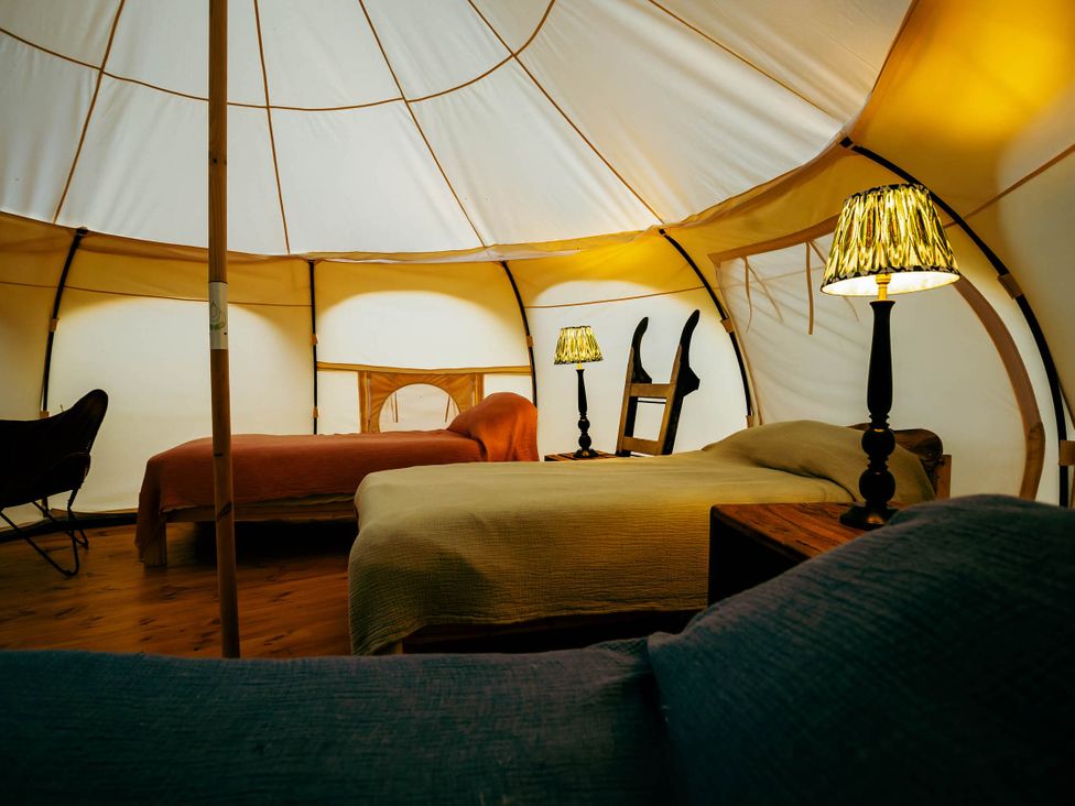 A bedroom with two beds and lamps in a tent at 