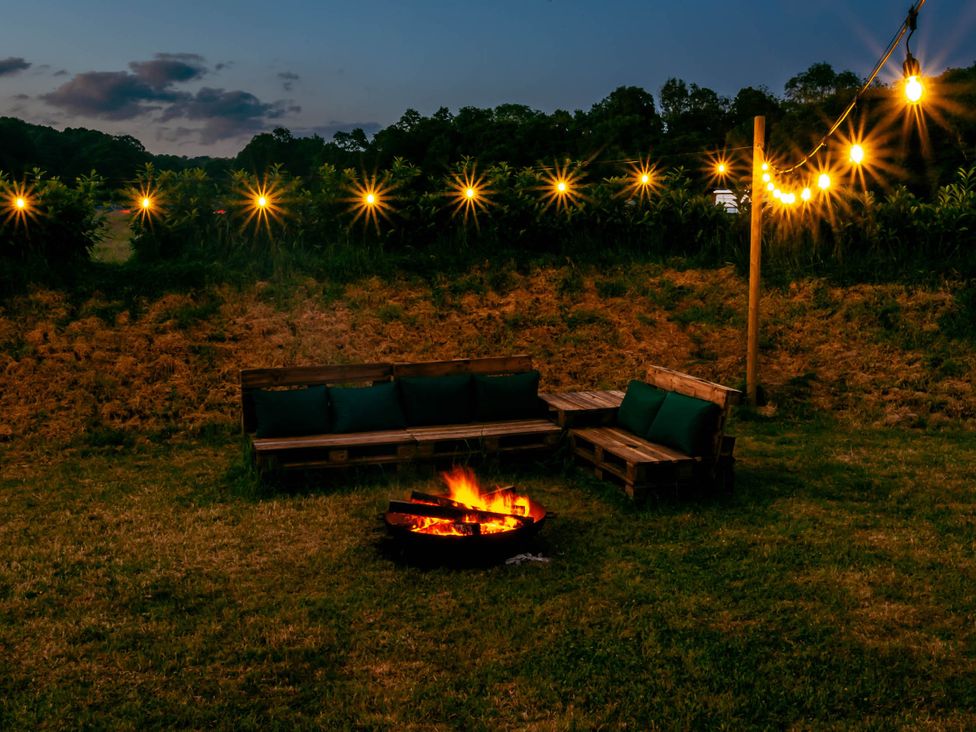 An outdoor seating area with a fire pit and string lights