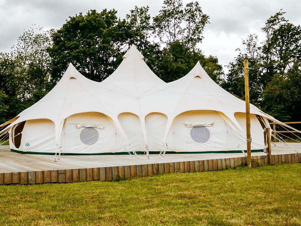 A white tent on a wooden deck in an outdoor setting