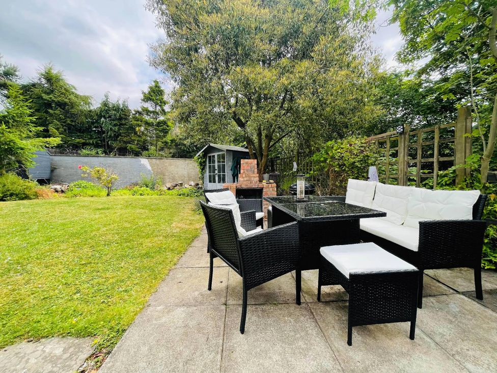 A garden with outdoor furniture and a shed in the background at The Old Barn in Manchester