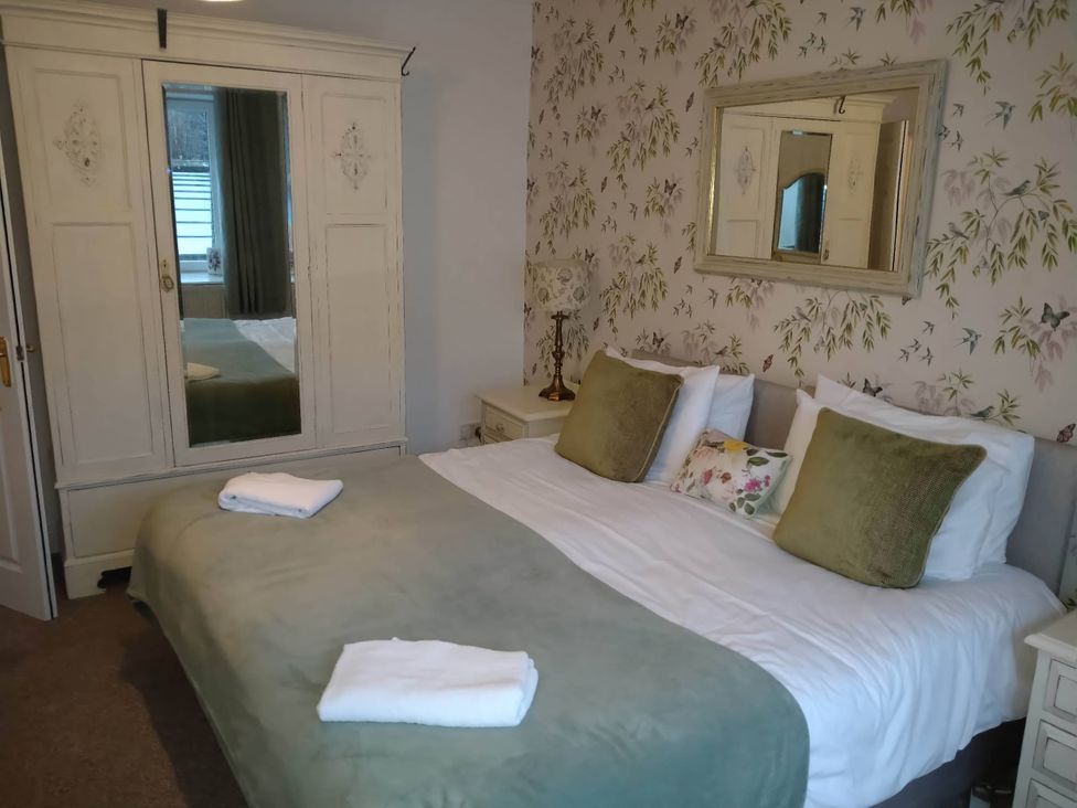 A bedroom with a bed and a wardrobe at The Old Barn in Manchester