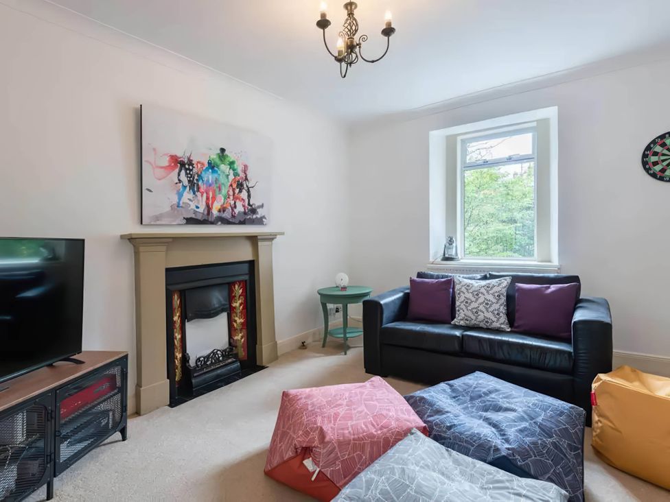 A living room with a sofa and television at The Old Barn in Manchester